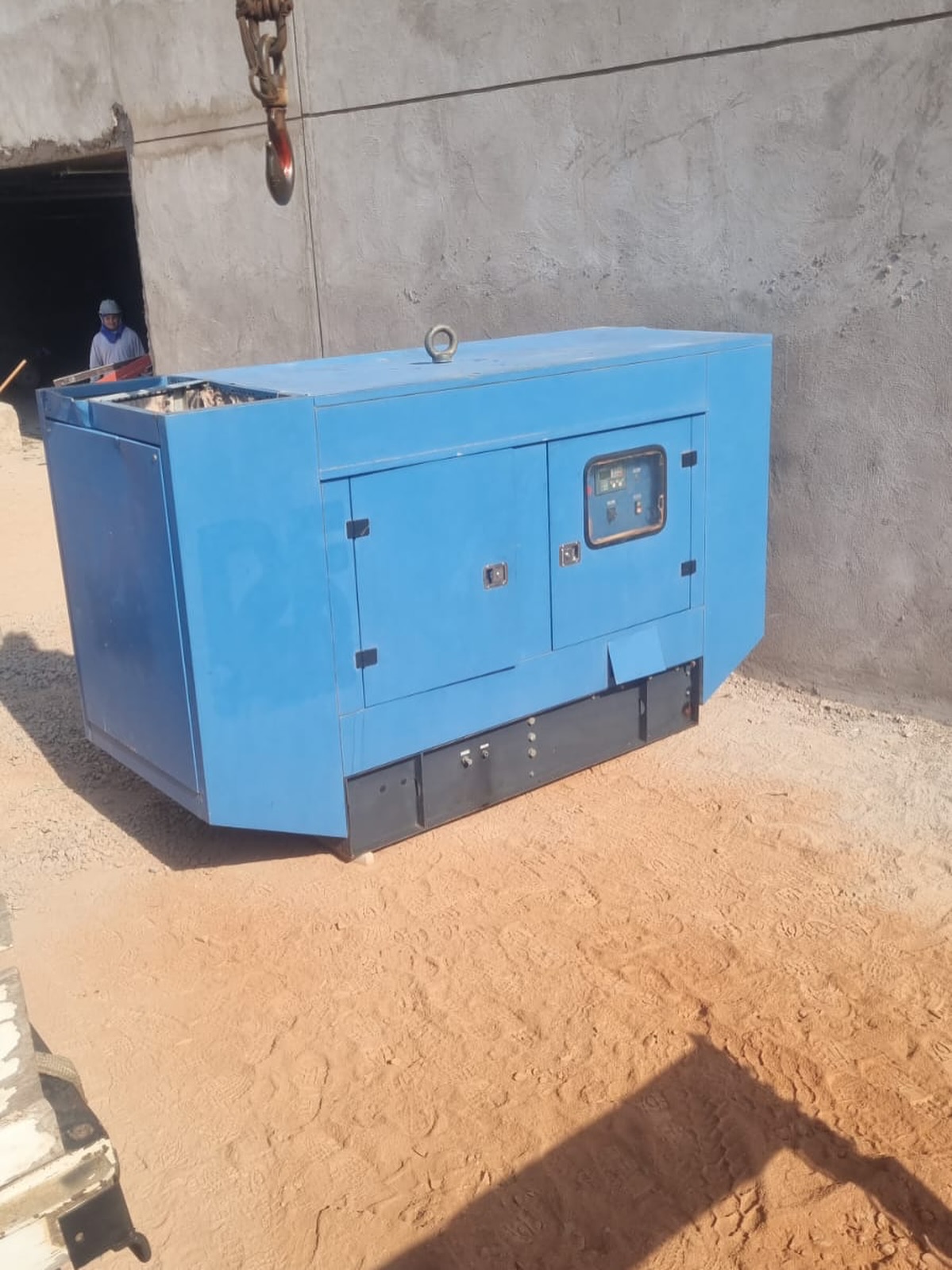 Gerador azul instalado em canteiro de obra